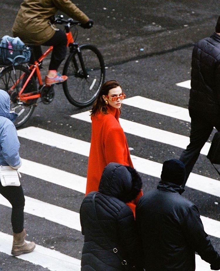 mujer pasando la calle en vestido rojo